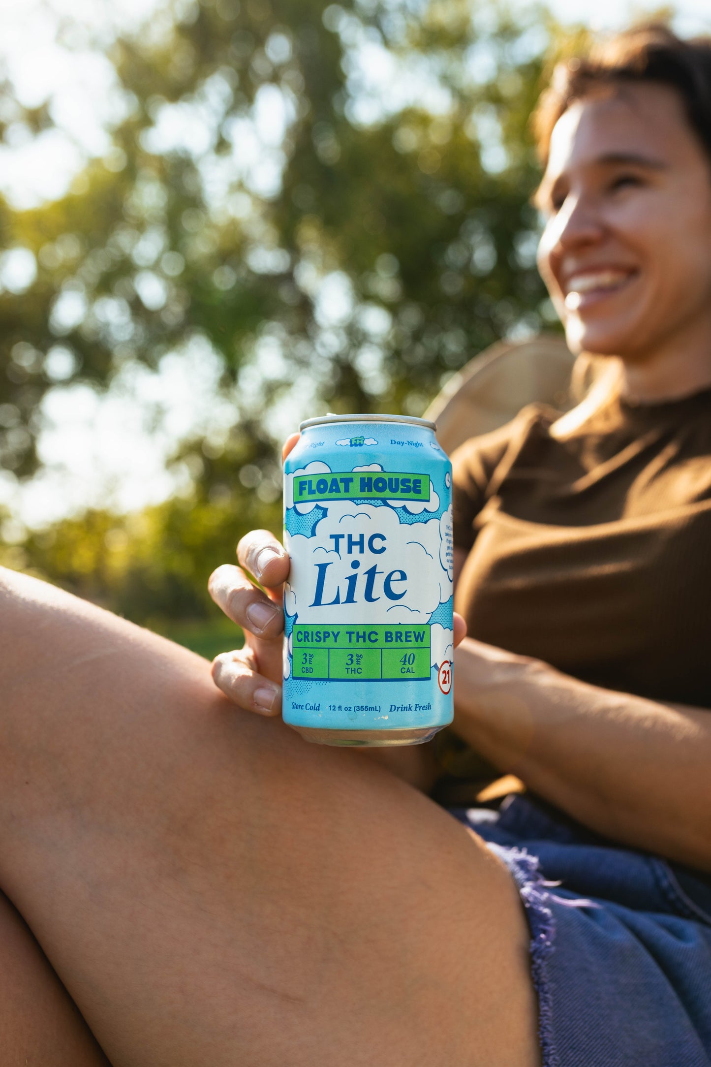 Person holding a can of 'THC Lite' with a natural background
